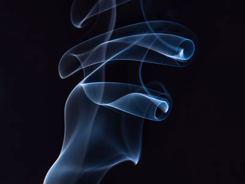 A wisp of pale smoke against black